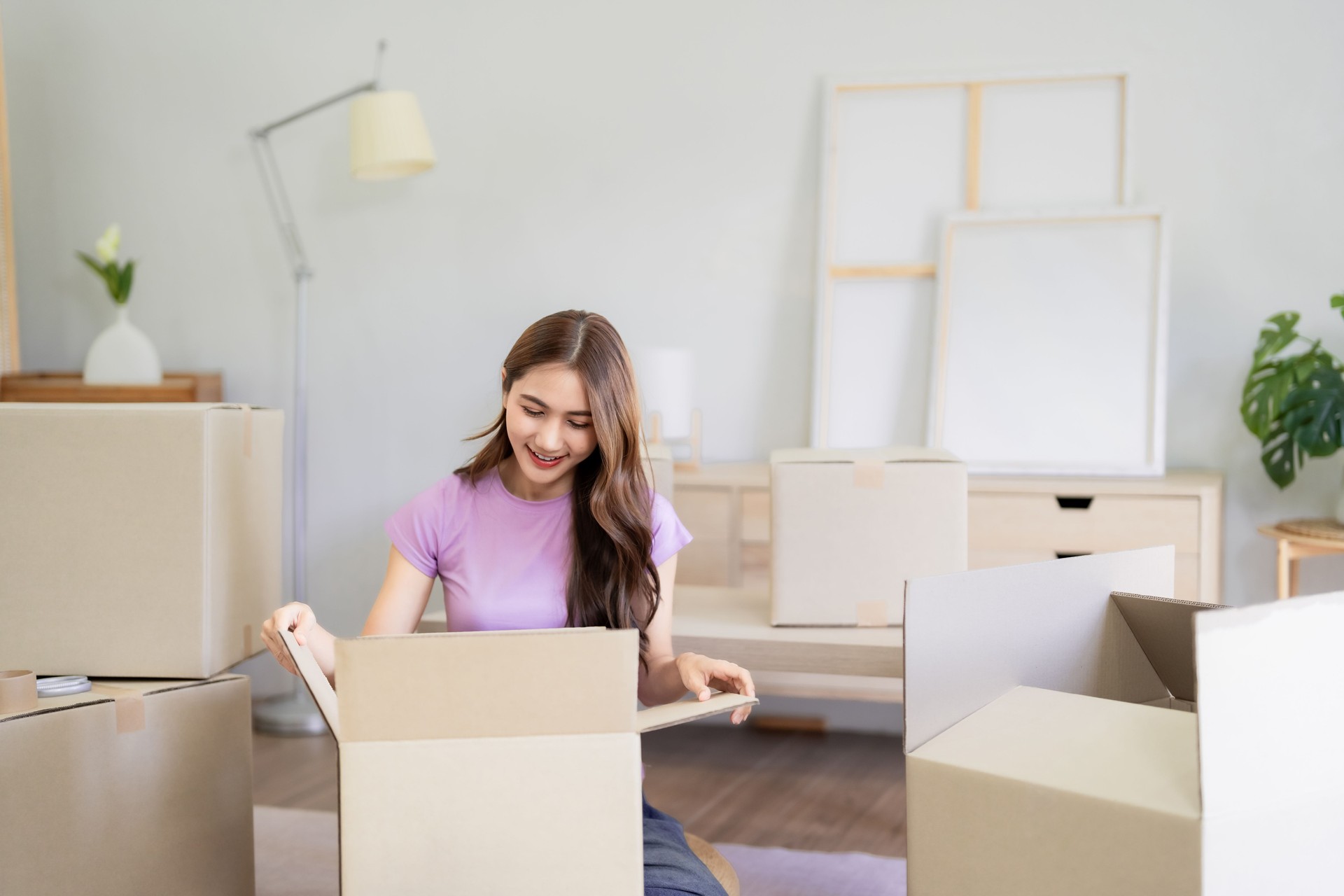 Asian Women Moving into New Home Unpacking Cardboard Boxes Feeling Happy Starting New Chapter in Life Decorating New Place Comfortable Living Space Modern Apartment